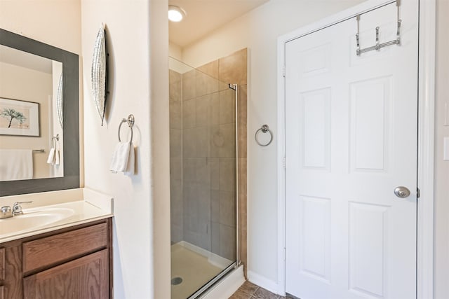 full bathroom with baseboards, a shower stall, and vanity