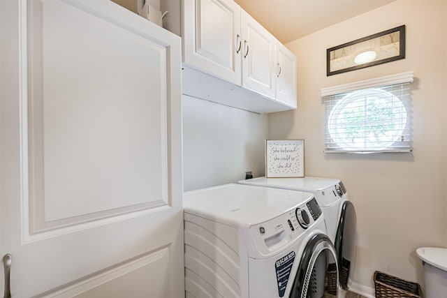 laundry area featuring cabinet space, separate washer and dryer, and baseboards