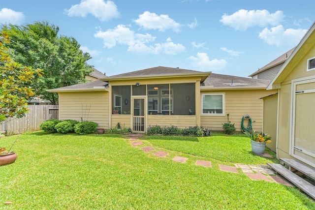 rear view of property with fence, a sunroom, a yard, and roof with shingles