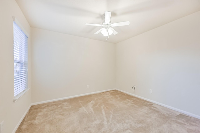 unfurnished room with baseboards, a healthy amount of sunlight, and light carpet