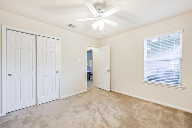unfurnished bedroom with baseboards, light carpet, a closet, and visible vents