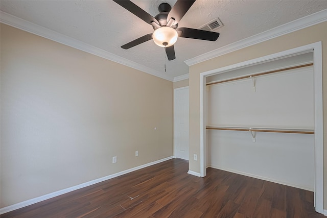 unfurnished bedroom with a textured ceiling, dark wood finished floors, baseboards, visible vents, and a closet