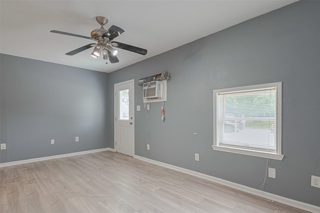 foyer with baseboards, light wood-style flooring, ceiling fan, and an AC wall unit