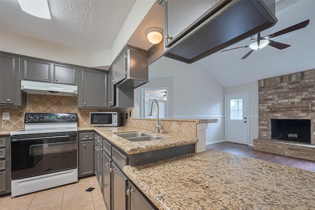 kitchen featuring electric range, ceiling fan, stainless steel microwave, under cabinet range hood, and a sink