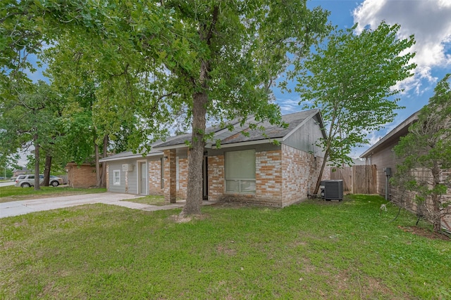 view of front of house featuring brick siding, fence, central air condition unit, and a front yard