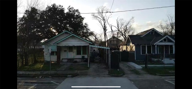 bungalow-style house featuring a porch and uncovered parking