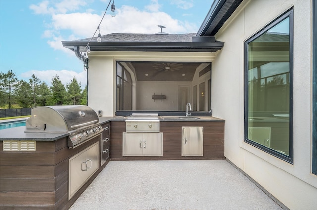 view of patio / terrace with a sink, an outdoor kitchen, and a grill