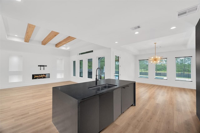 kitchen with visible vents, a sink, light wood-style floors, and open floor plan