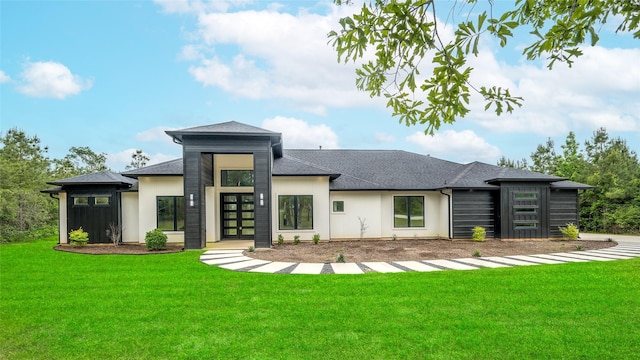 back of property featuring a lawn, roof with shingles, and stucco siding