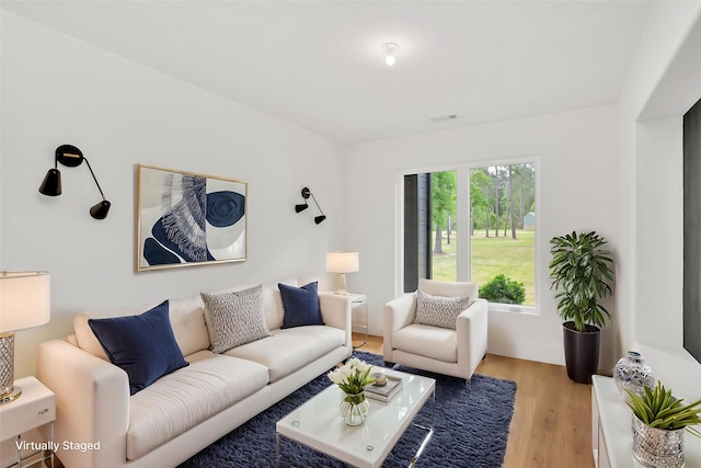 living area with light wood-style flooring and visible vents