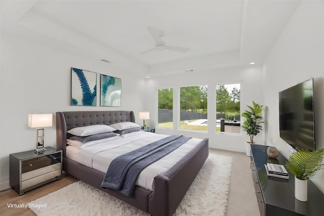 bedroom with a ceiling fan, visible vents, and a raised ceiling