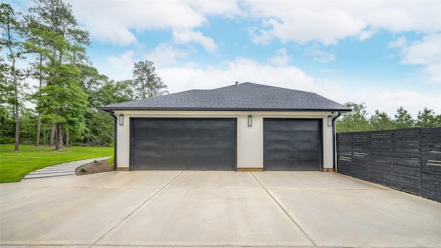 garage with fence and driveway
