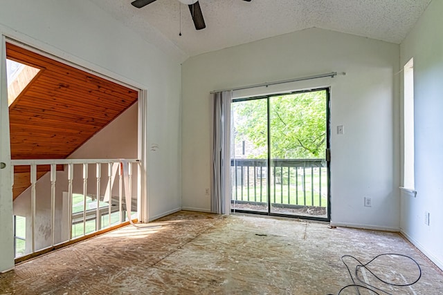 spare room featuring a textured ceiling, ceiling fan, vaulted ceiling, and baseboards
