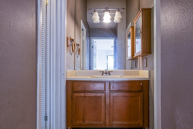 bathroom featuring a textured wall and vanity