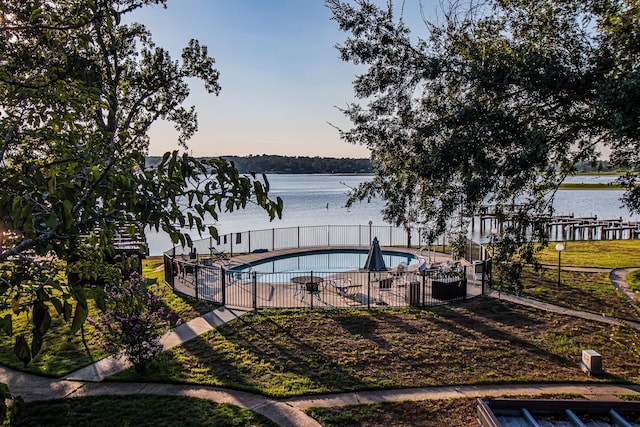 view of swimming pool featuring fence, a fenced in pool, and a water view