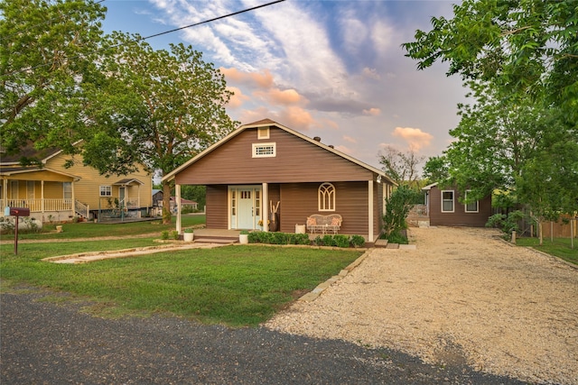 303 S Mechanic St, Fayetteville, TX 78940 - bungalow featuring a porch, dirt driveway, and a lawn