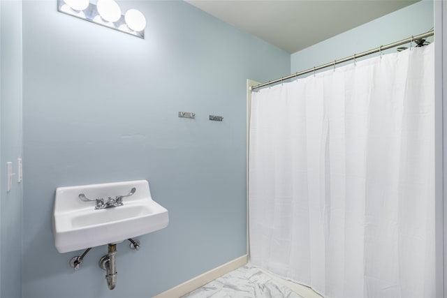 303 S Mechanic St, Fayetteville, TX 78940 - bathroom with baseboards, a sink, marble finish floor, and a shower with curtain