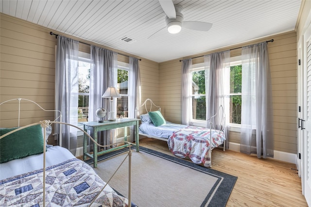 303 S Mechanic St, Fayetteville, TX 78940 - bedroom with visible vents, wood walls, a ceiling fan, and wood finished floors
