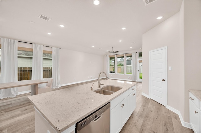 kitchen featuring stainless steel dishwasher, a sink, visible vents, and light wood-type flooring