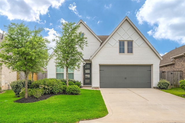 view of front facade with a front lawn, fence, brick siding, concrete driveway, and an attached garage