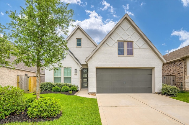 view of front of home featuring a front yard, brick siding, fence, concrete driveway, and an attached garage