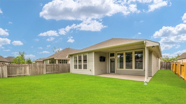 back of property with a patio, a fenced backyard, and a lawn