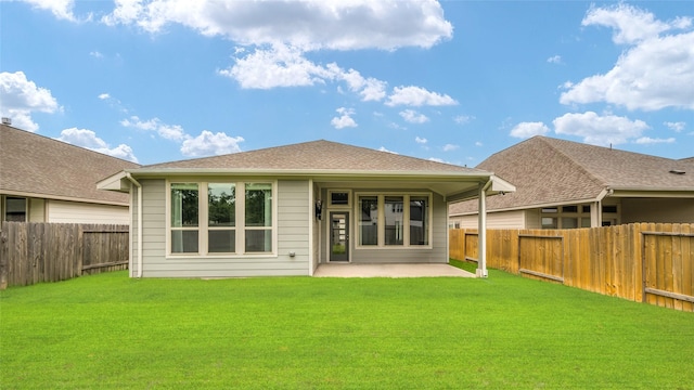 rear view of property with a patio, a fenced backyard, and a yard