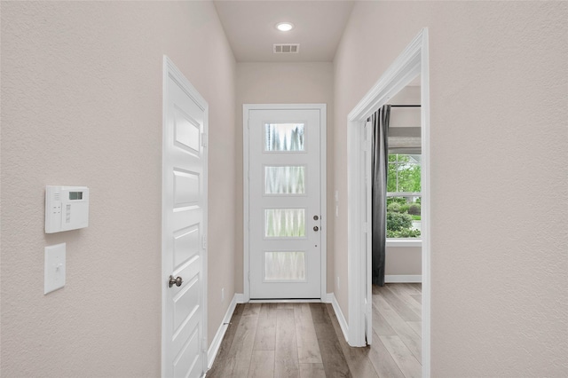 entryway with baseboards, visible vents, and wood finished floors