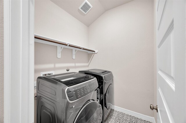 laundry area with laundry area, baseboards, washing machine and dryer, and visible vents