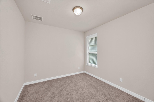 carpeted spare room with baseboards and visible vents