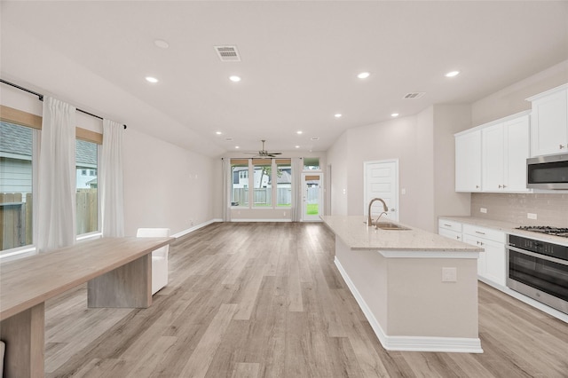kitchen featuring ceiling fan, a sink, light wood finished floors, stainless steel appliances, and visible vents