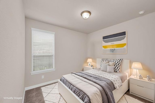 bedroom with baseboards, light colored carpet, and multiple windows