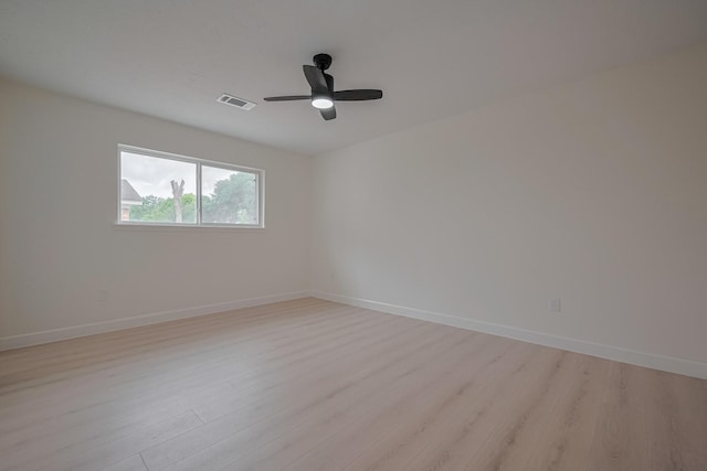 spare room with visible vents, a ceiling fan, baseboards, and light wood-type flooring