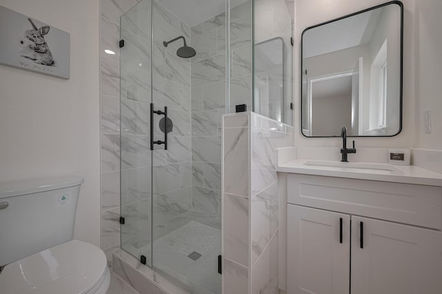 full bath with vanity, a stall shower, and toilet