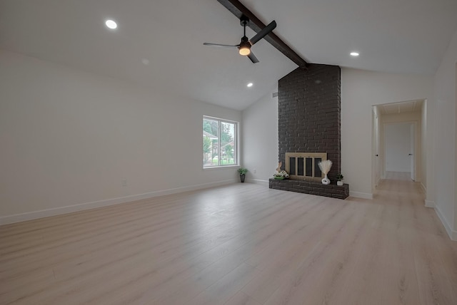 unfurnished living room with a ceiling fan, baseboards, attic access, and light wood-type flooring