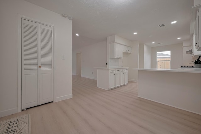 unfurnished living room featuring visible vents, recessed lighting, baseboards, and light wood-type flooring