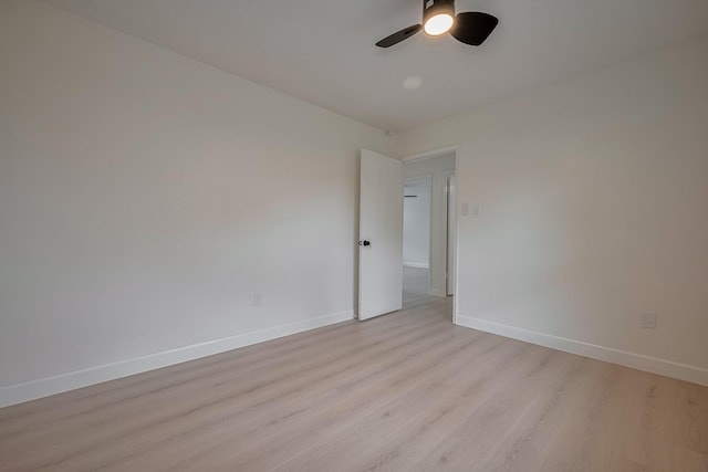 unfurnished room with light wood-style floors, a ceiling fan, and baseboards