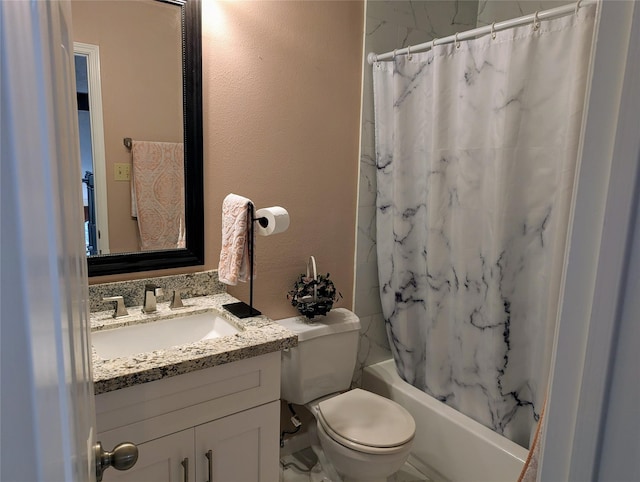full bath featuring vanity, a textured wall, shower / bath combo, and toilet