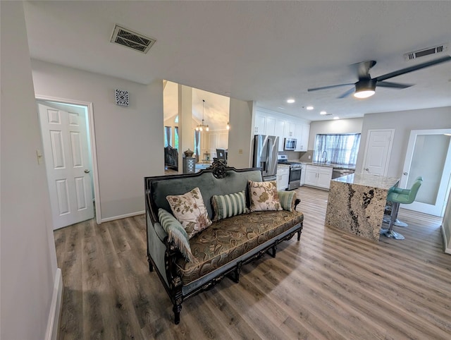 2 Skyland Pl, The Woodlands, TX 77381 - living area featuring baseboards, wood finished floors, a ceiling fan, a chandelier, and recessed lighting