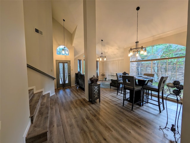 2 Skyland Pl, The Woodlands, TX 77381 - dining space featuring a chandelier, high vaulted ceiling, wood finished floors, stairs, and ornamental molding