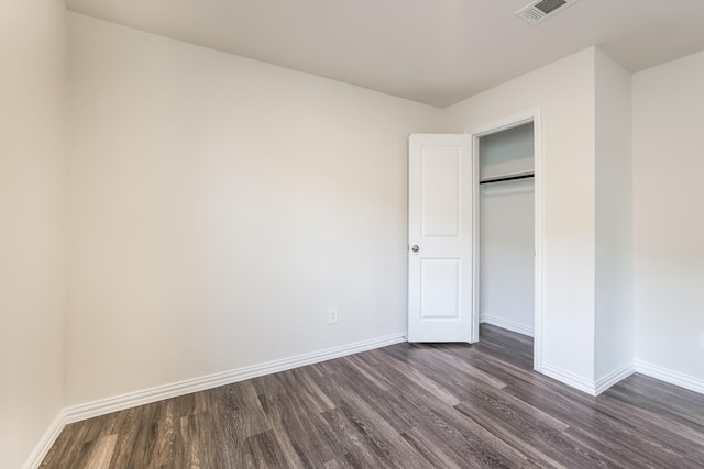 unfurnished bedroom with visible vents, baseboards, and dark wood-type flooring