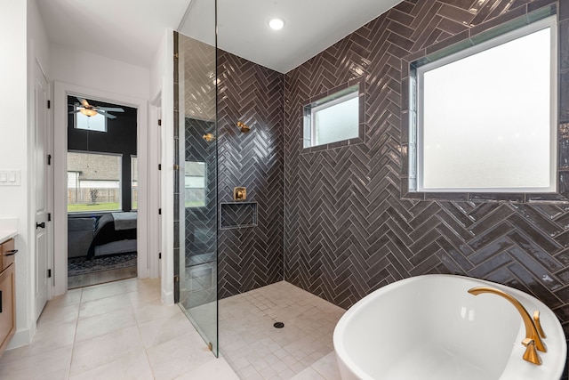full bath with a ceiling fan, tile walls, a freestanding tub, a walk in shower, and tile patterned floors