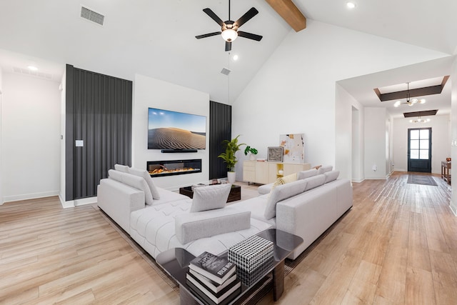 living area with visible vents, light wood finished floors, high vaulted ceiling, and beamed ceiling