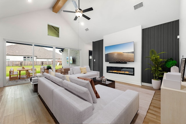 living room with a ceiling fan, visible vents, wood finished floors, high vaulted ceiling, and beamed ceiling