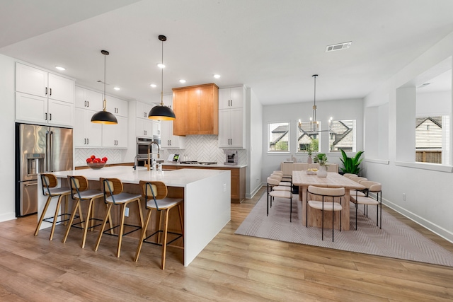 kitchen featuring visible vents, a healthy amount of sunlight, light countertops, appliances with stainless steel finishes, and backsplash