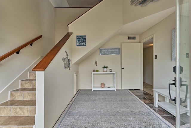 additional living space with visible vents, stone tile flooring, and stairway