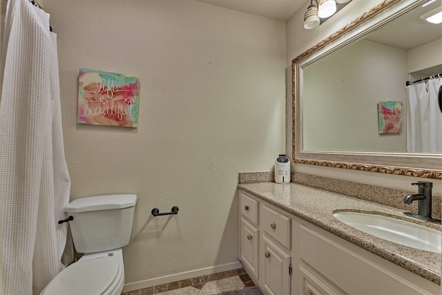 bathroom with vanity, baseboards, and toilet