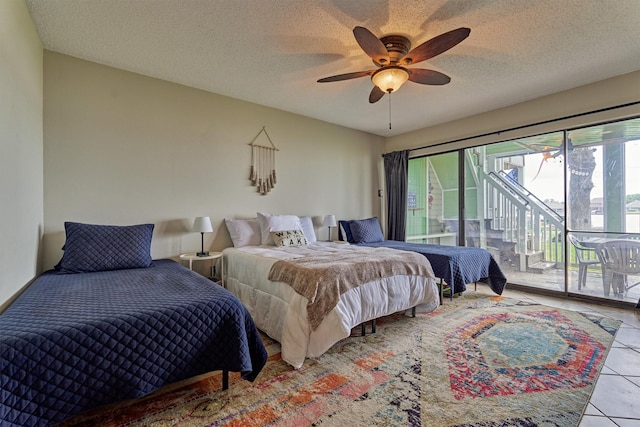 bedroom with tile patterned flooring, access to outside, a ceiling fan, and a textured ceiling