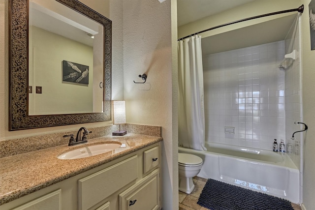 bathroom with vanity, shower / bathtub combination with curtain, a textured wall, and toilet