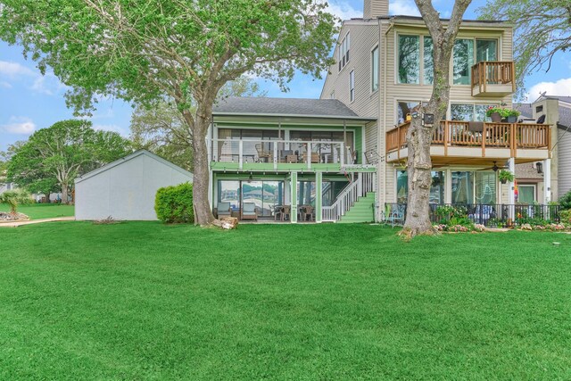 2012 Lakewood Ct, Willis, TX 77318 - rear view of property with a shingled roof, a sunroom, a deck, stairway, and a lawn
